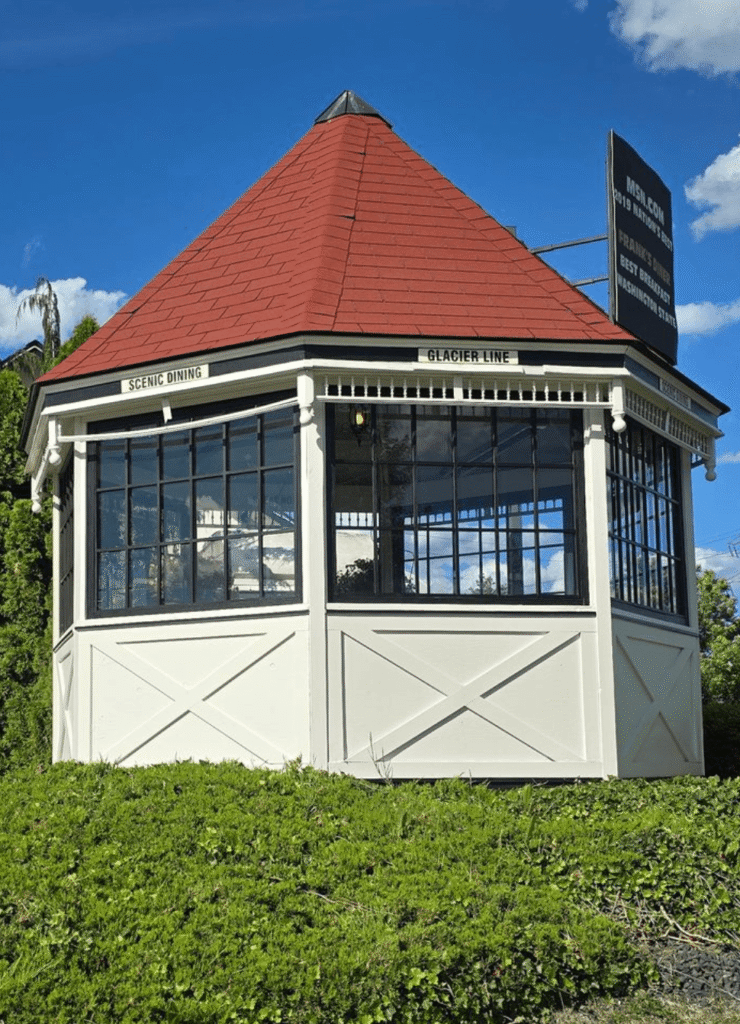 Freshly painted white restaurant dining pavilion with black window trim and a red roof.